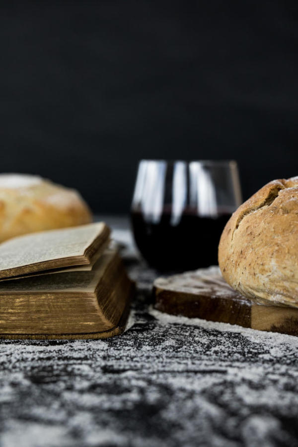 Bible and communion elements wine and bread on table top
